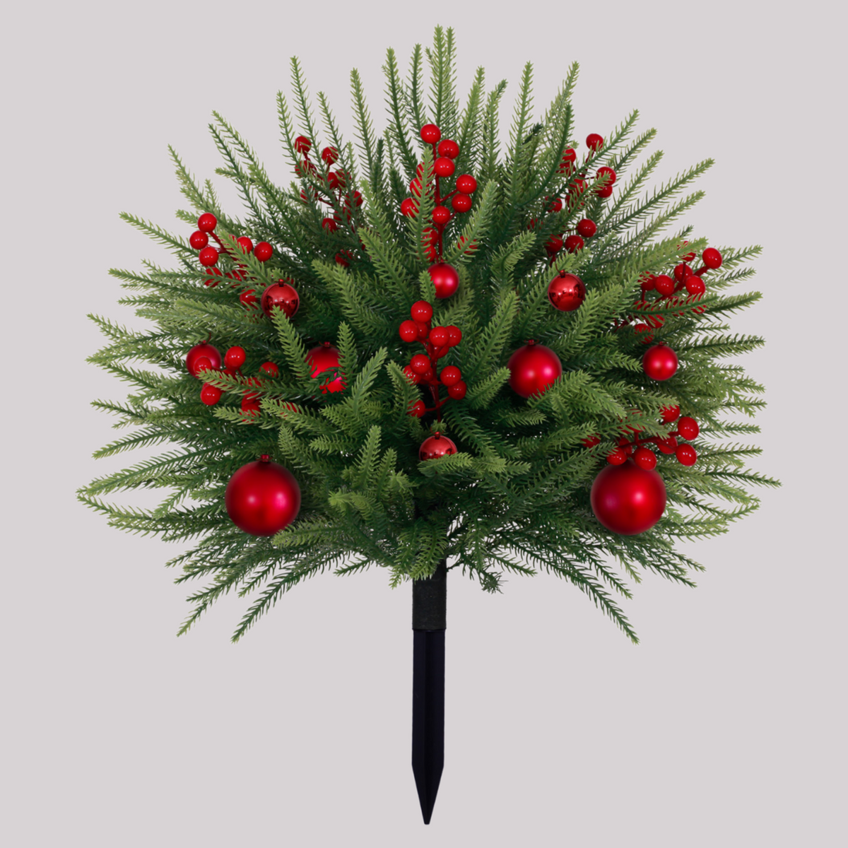 25 inch bushy artificial christmas tree decorated with red baubles and red berry sprigs, equipped with ground spike