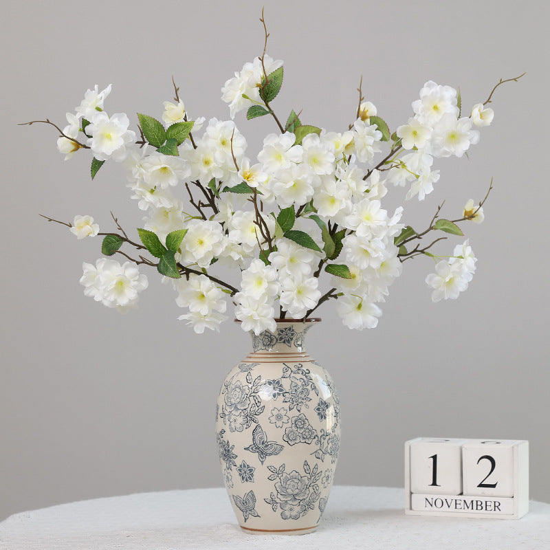 Full white peach flowers bouquet arranged in vintage blue print ceramic vase for entryway home decor