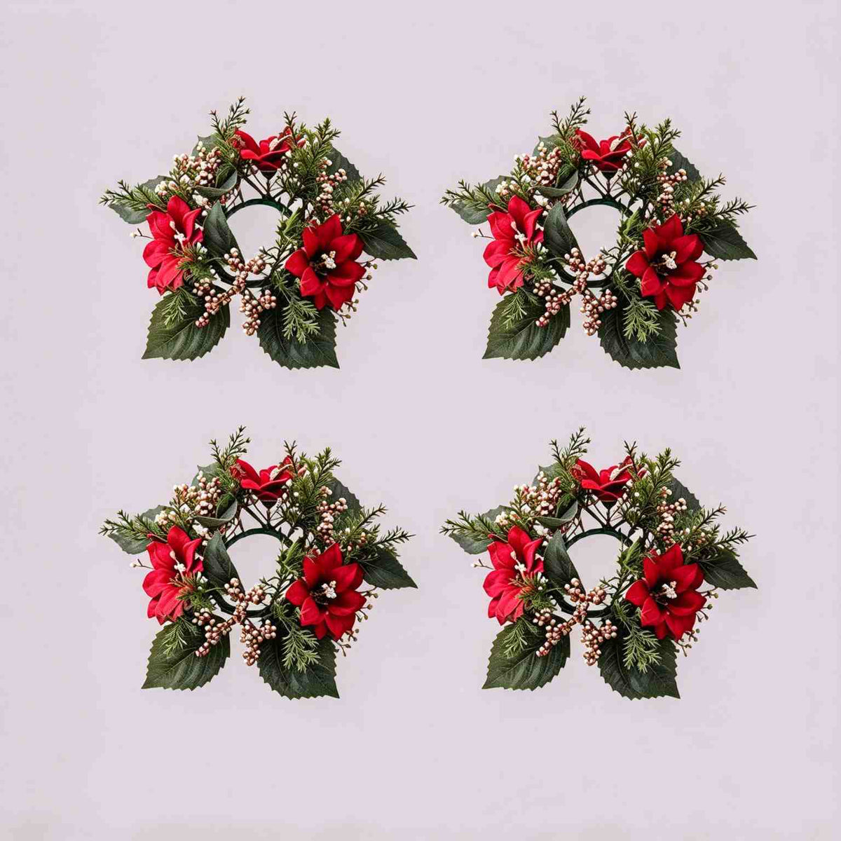 4 pack Christmas poinsettia candle rings with red poinsettia blooms, gold berries and cedar foliage on light grey background