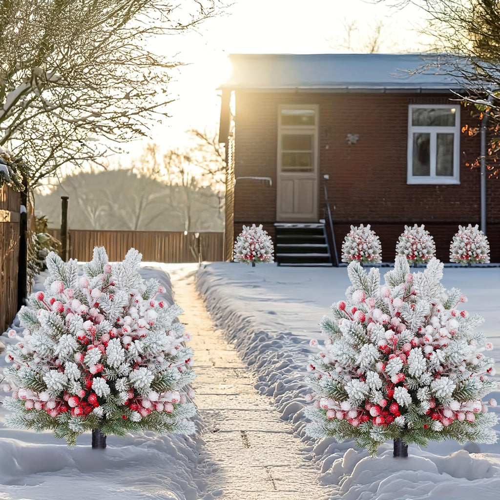 Artificial snow norfolk pine with red berries lining snowy garden pathway in front of brick house at golden hour sunset for magical christmas winter outdoor landscape decor