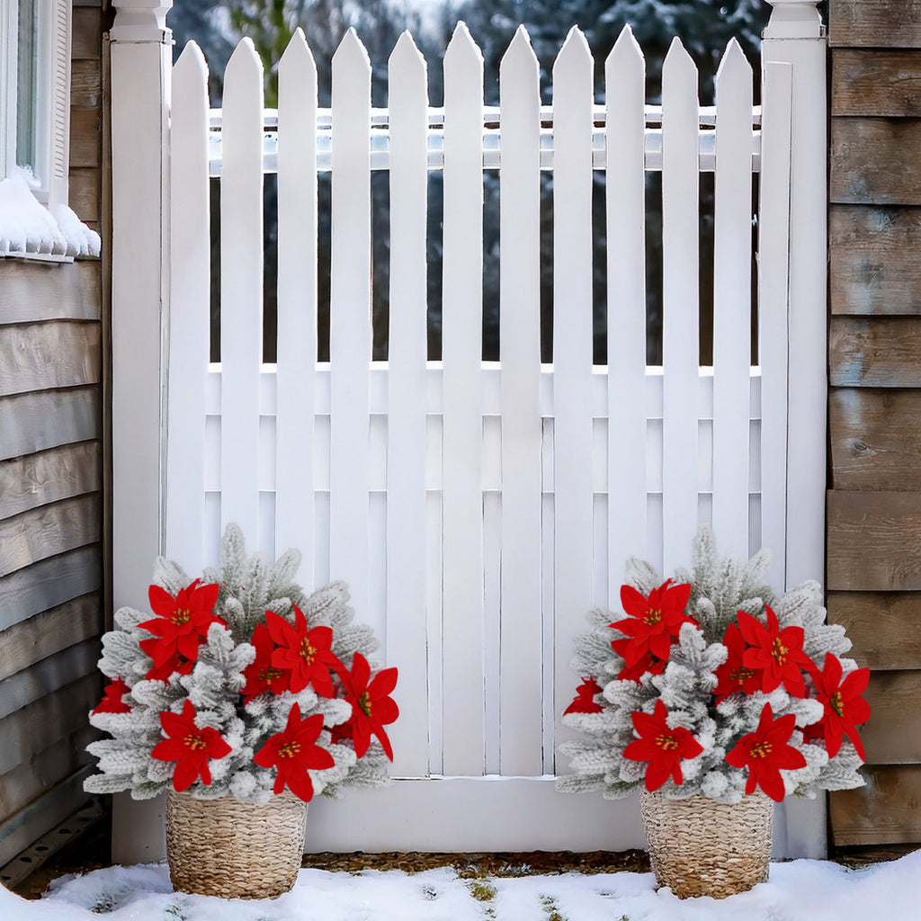 Multiple snow flocked artificial trees with poinsettia accents for full winter yard and fence landscaping