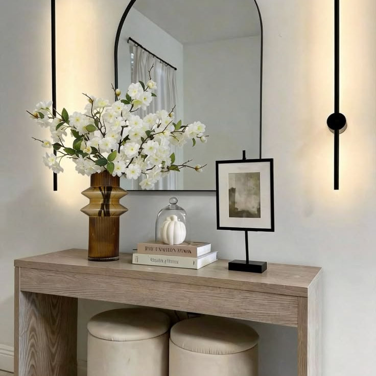 Lush branching white spring blossom faux flowers paired with amber ribbed vase for neutral hallway console decor