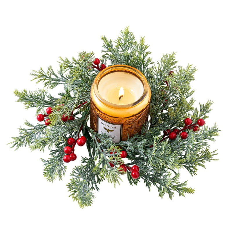 Top-down shot of cypress red berry candle ring encircling amber jar candle, isolated on clean white background