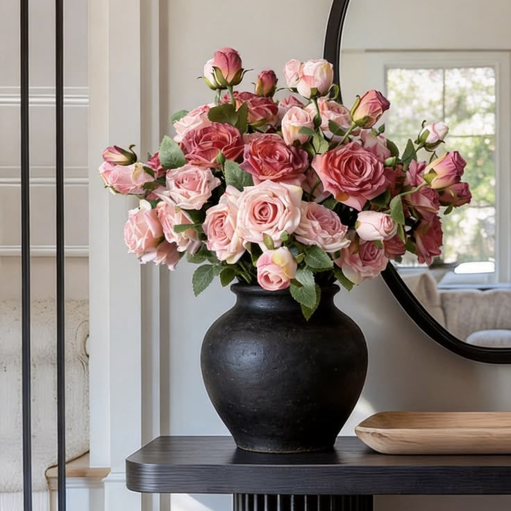 Full rounded dusty pink rose silk flowers bouquet with fresh green leaves for modern fluted entry table styling