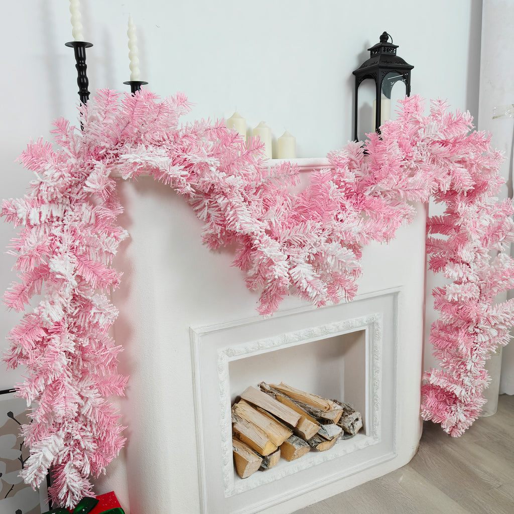 Soft flocked pink winter pine christmas garlands styled on white mantel with pillar candles & black lantern decor