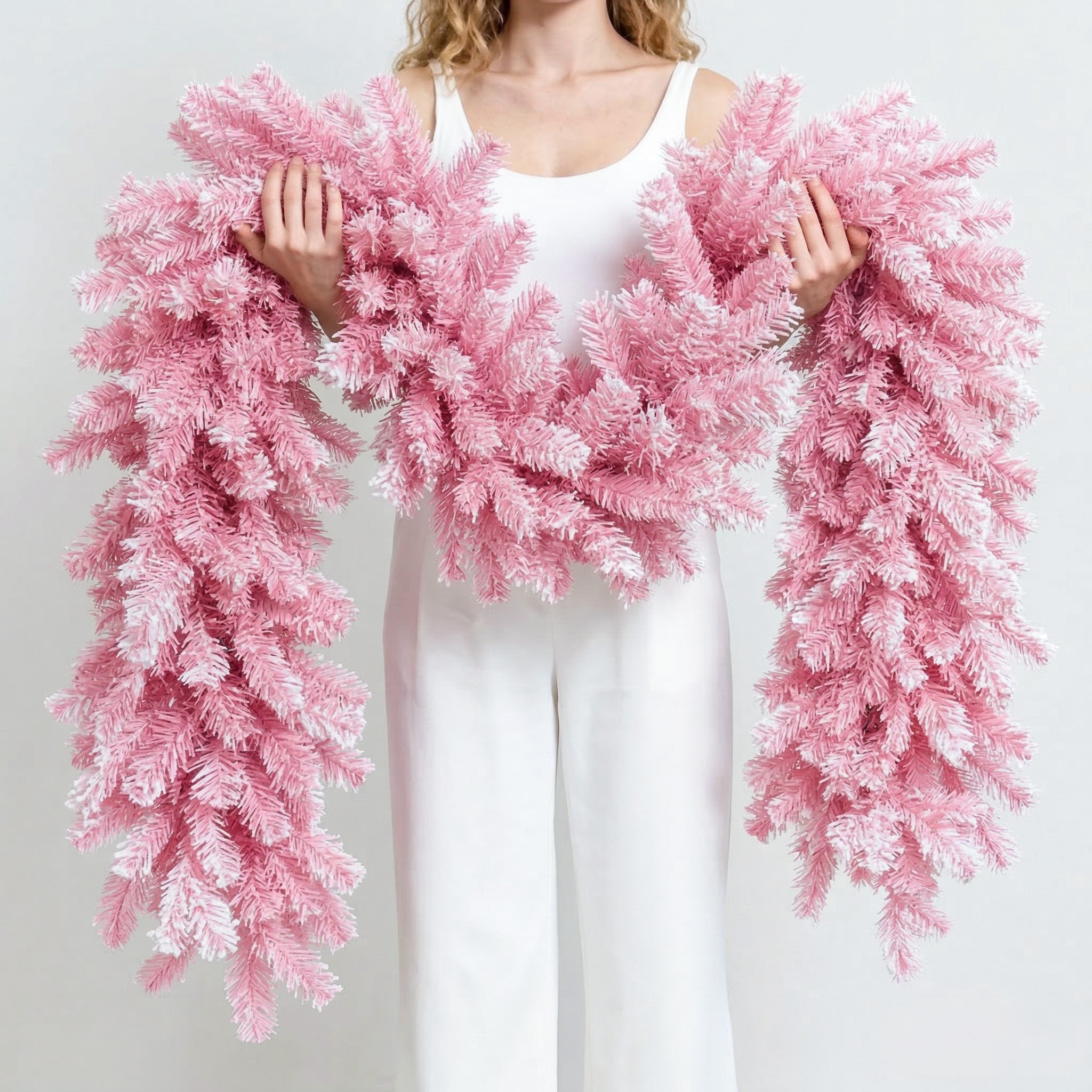 Extra fluffy flocked pink pine artificial christmas garland hand held to show thick realistic branch texture
