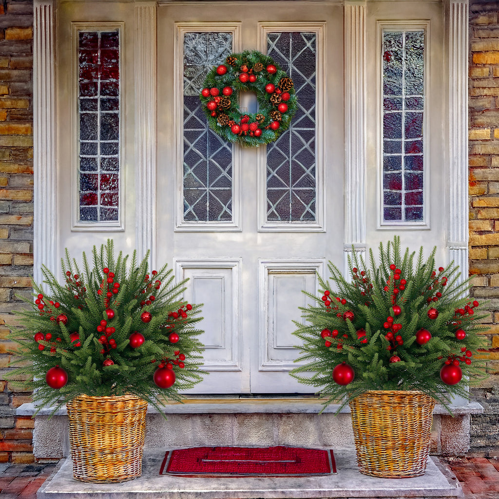 Symmetrical pair of decorated artificial christmas trees with red baubles for farmhouse entryway matching styling