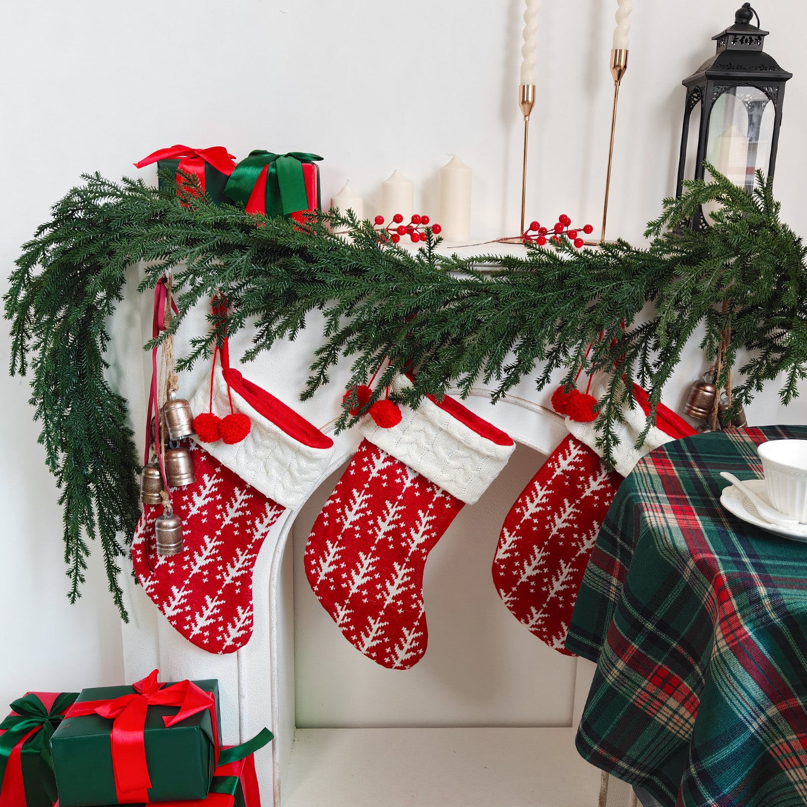 Natural drooping norfolk pine artificial christmas garland styled on white mantel with knit stockings & gift boxes