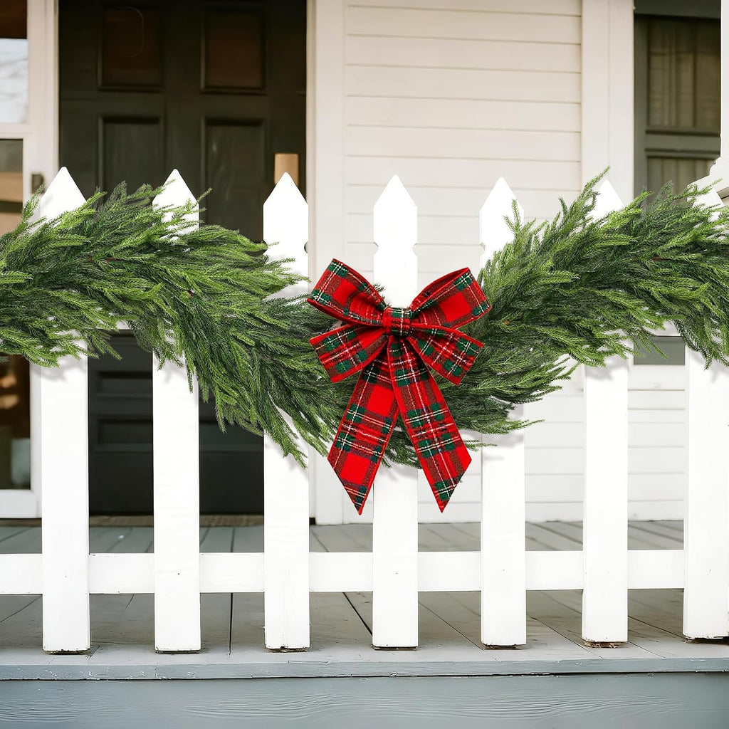Natural green Norfolk Pine Garland decorated with red tartan bow for front porch picket fence holiday decor