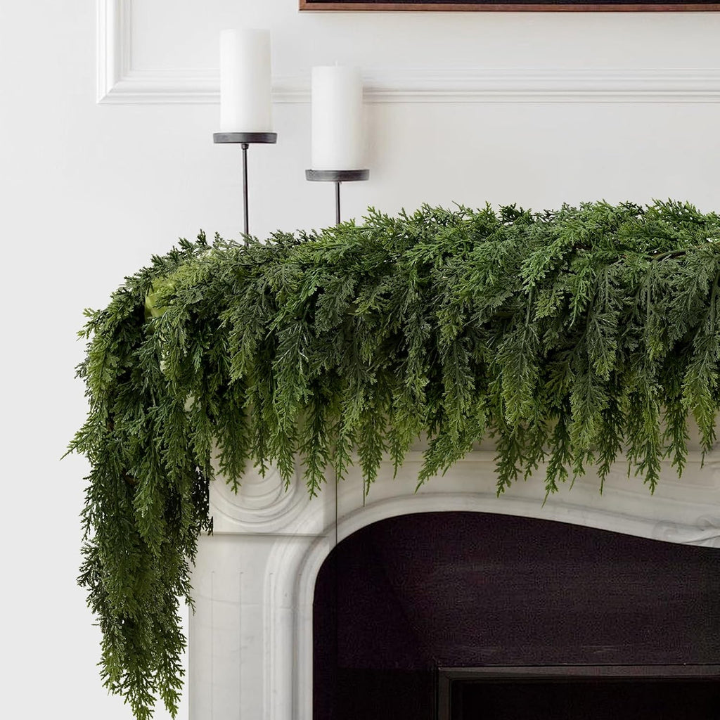 Natural drooping cedar artificial christmas garland laid across white marble mantel minimalist winter interior decor