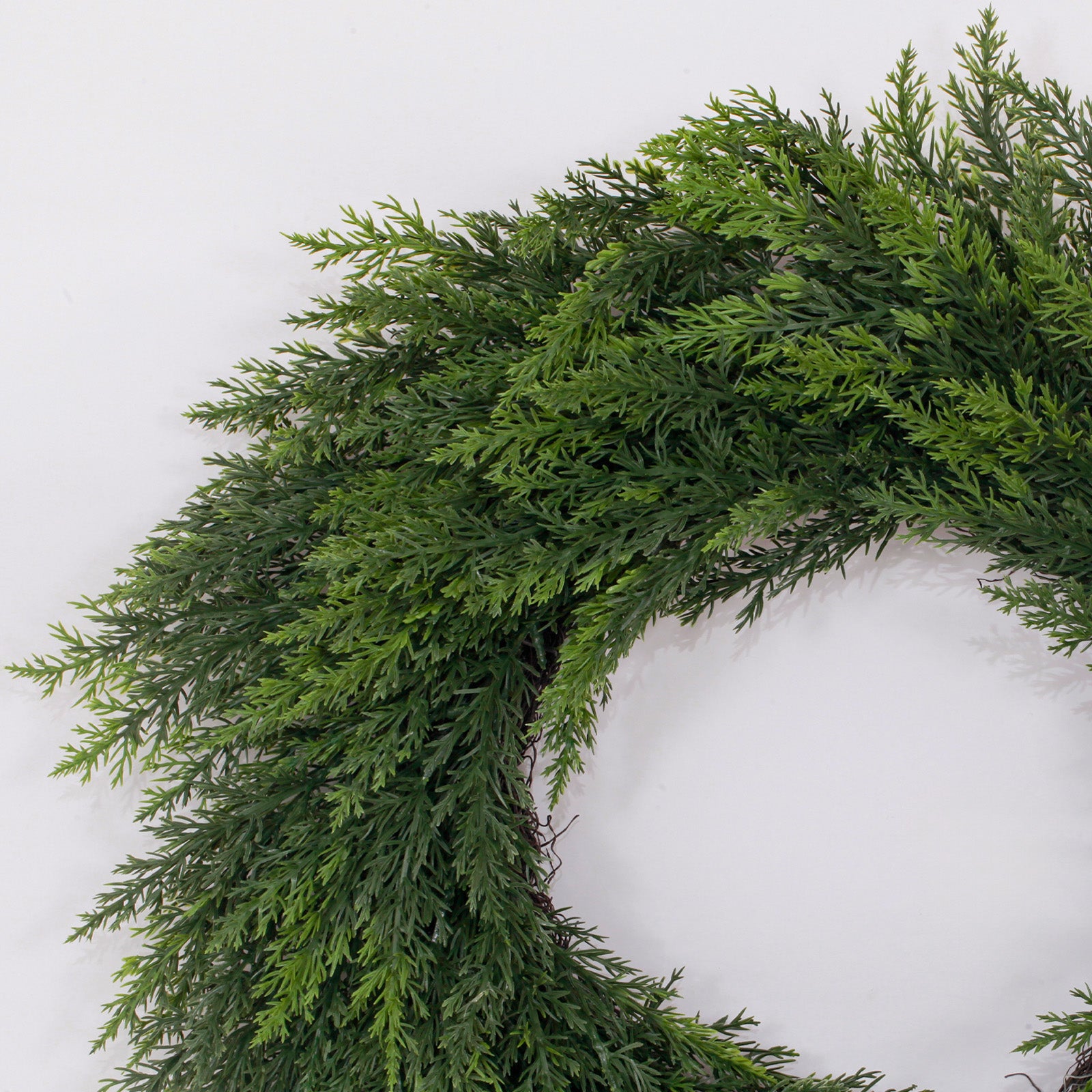 Closeup layered norfolk pine laurel wreath showcasing soft natural drooping evergreen leaf texture