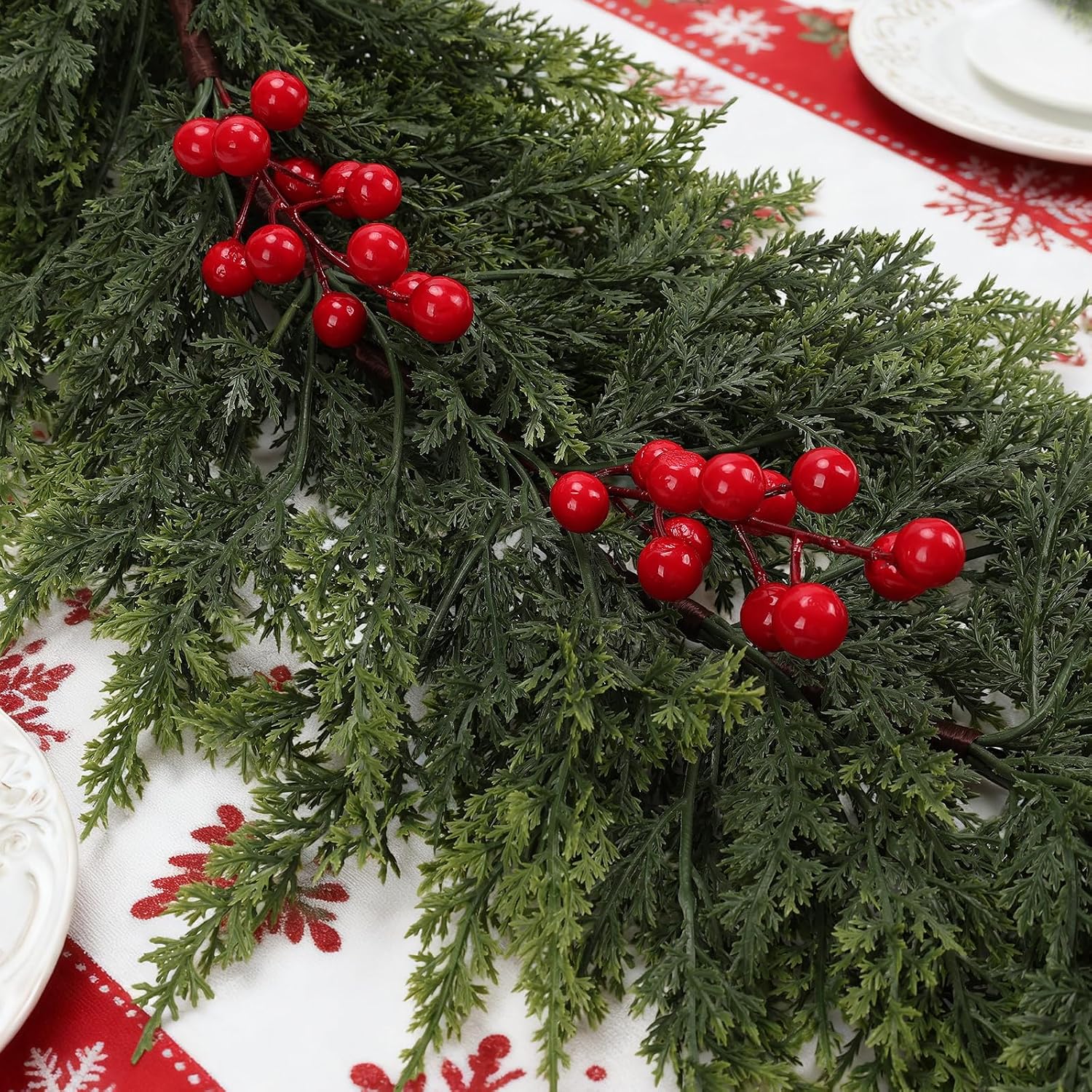 Lush cedar red berry Norfolk Pine Garland close up laid on holiday dining table cloth for Christmas table decor