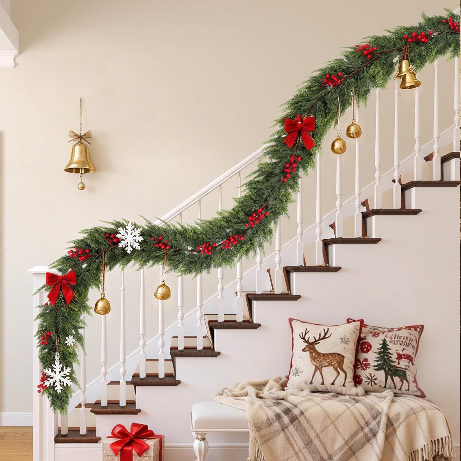 Draped red berry Norfolk Pine Garland decorated with red bow brass bells on white staircase railing Christmas styling