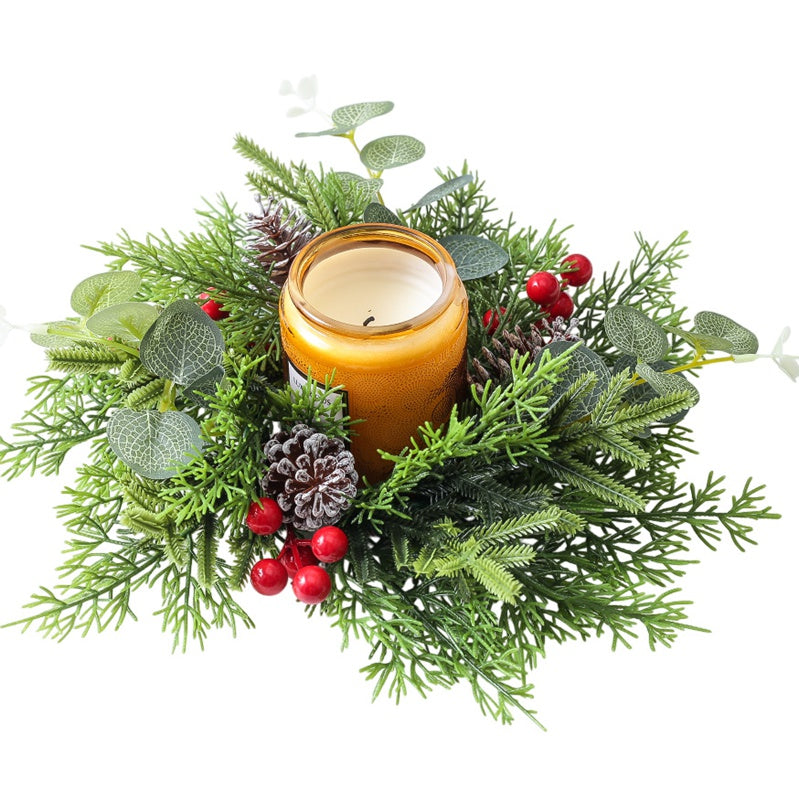 Top view Christmas candle ring with eucalyptus, pine cones and red berries paired with amber jar candle isolated on white background