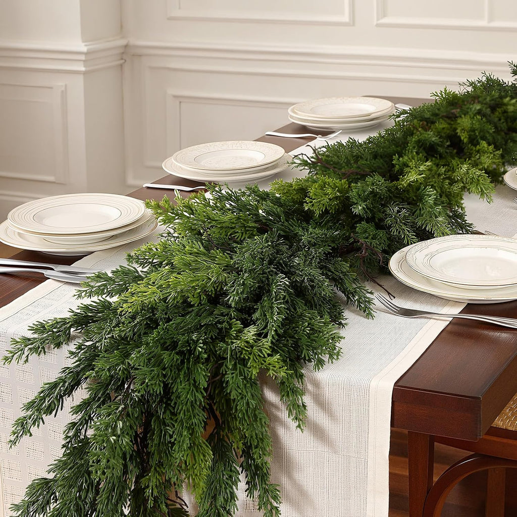 Unadorned realistic cedar artificial christmas garland used as dining table runner for neutral festive table centerpiece