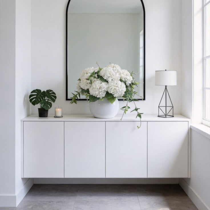 Large fluffy white hydrangea silk flowers arrangement with trailing green vines for minimalist modern entry cabinet styling